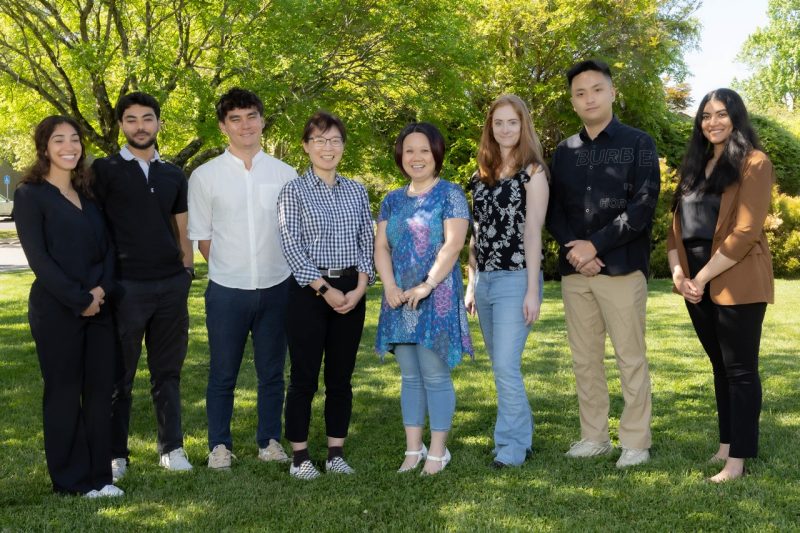 Group photo of the Xin Luo Lab outside of the Veterinary Teaching Hospital at the Virginia Maryland College of Veterinary Medicine.