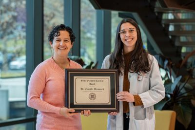 Two people holding a certificate and smiling.