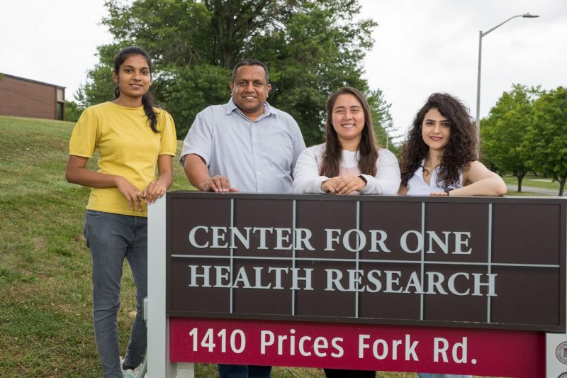 Gaji lab members standing in front of the Center for One Health Research sign.